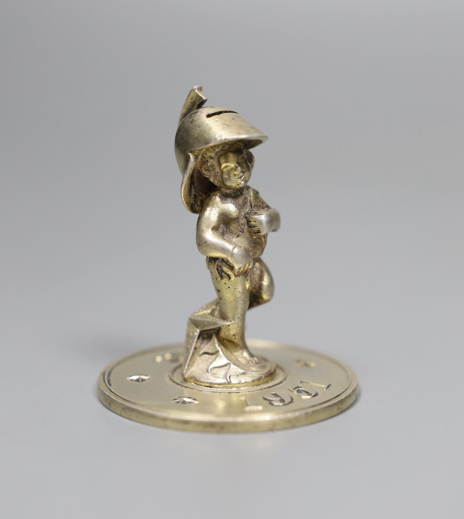 A silver-gilt Festival of Britain figural paperweight, Lesley Gordon Durbin, London 1950, 5cm